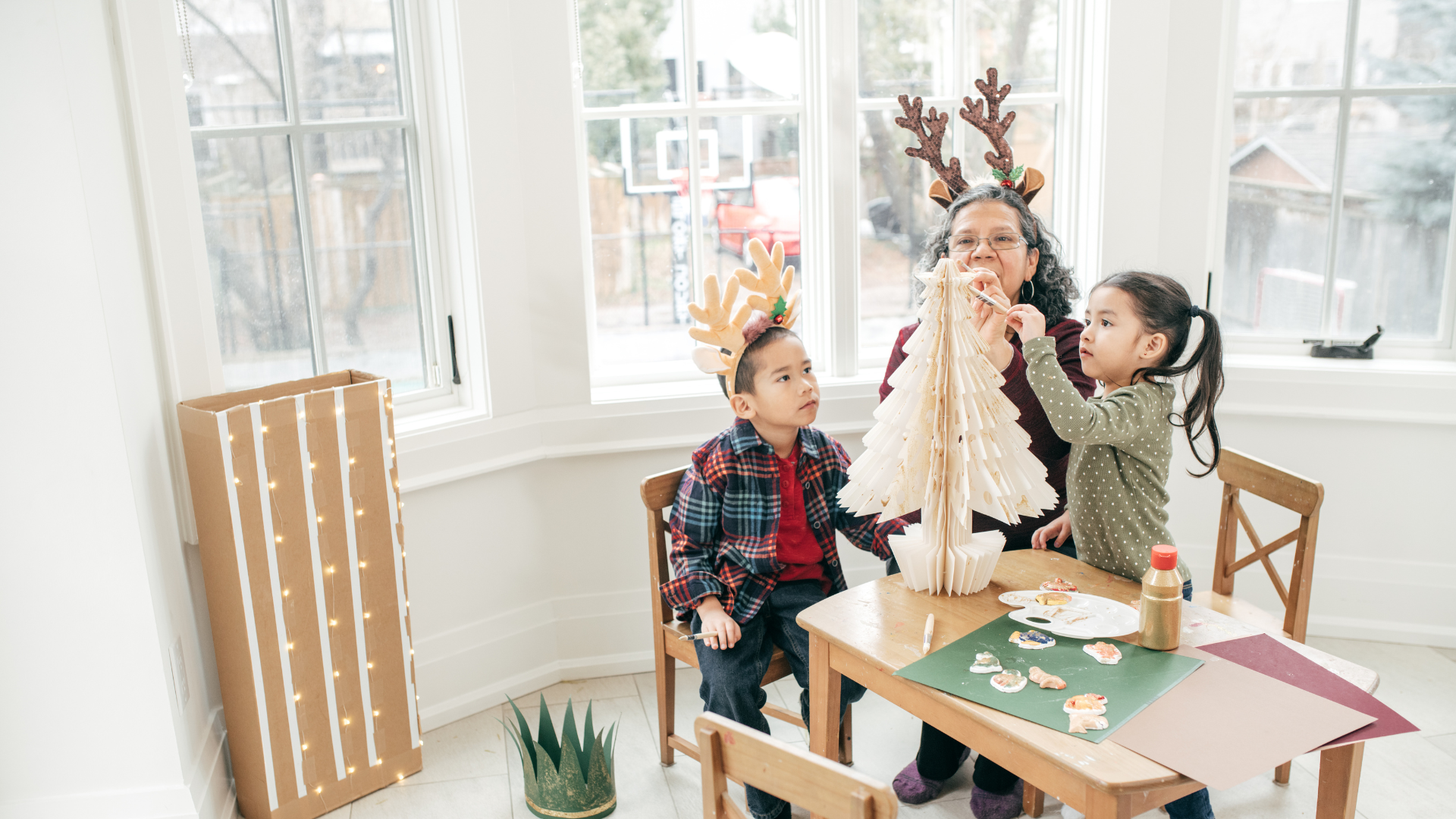 2 children waiting building a paper christmas tree